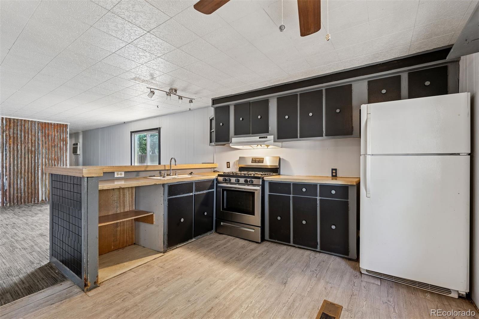 1044 Mac Davidson Circle Dacono, CO 80514 - Photo 3 of 25 a kitchen with a refrigerator and a stove top oven