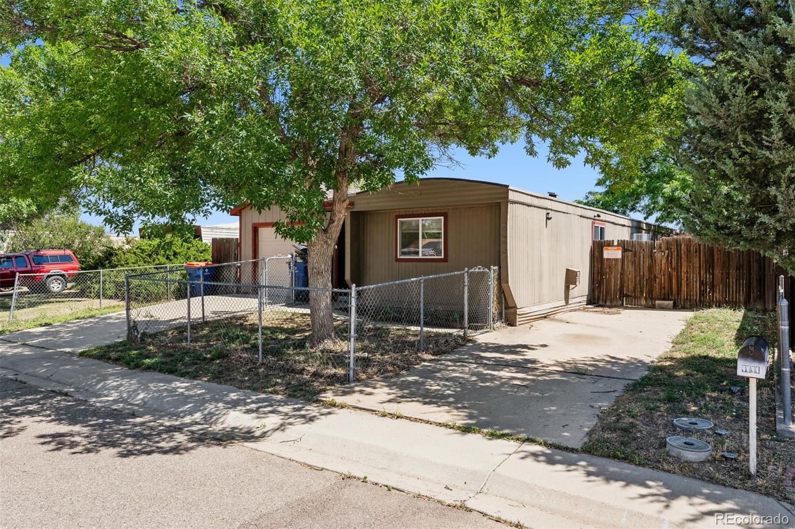 1044 Mac Davidson Circle Dacono, CO 80514 - Photo 4 of 25 a front view of a house with a yard and garage