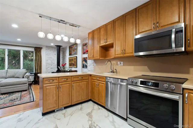 a kitchen with stainless steel appliances a stove microwave and sink