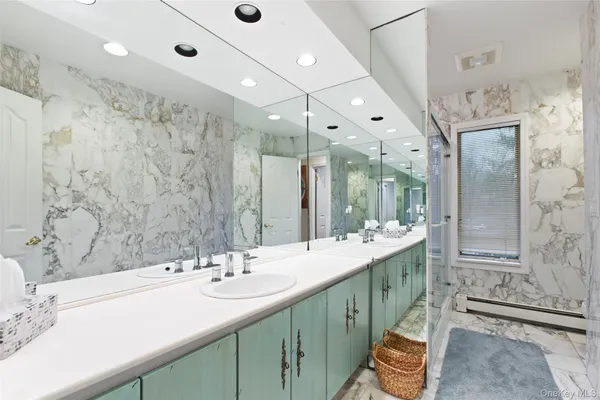 a bathroom with double vanity sinks and a large mirror