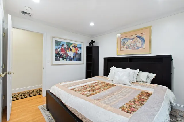 a bedroom with a bed and painting on the wall