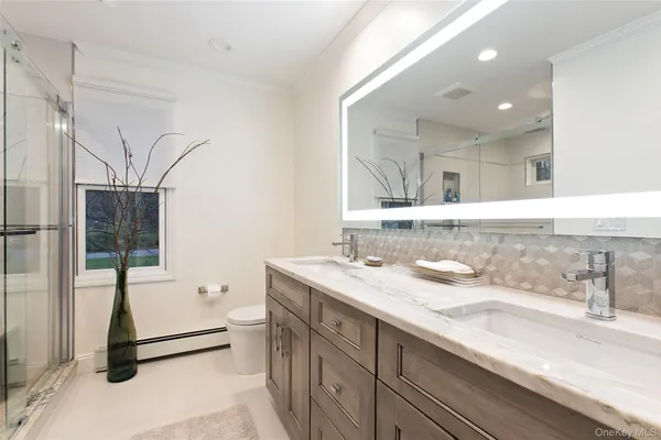 a spacious bathroom with a granite countertop sink a mirror and a bathtub