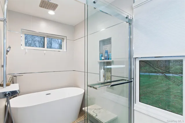 a bathroom with a white tub shower and toilet