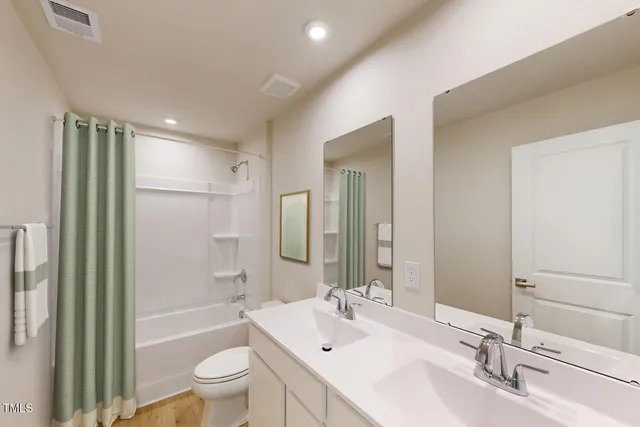 a bathroom with a bathtub shower sink mirror vanity and a toilet