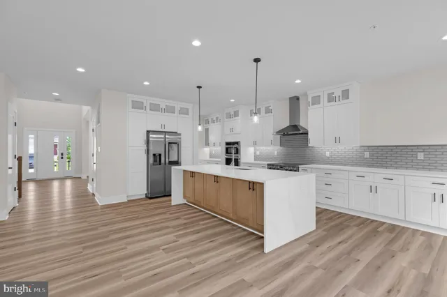 a large kitchen with granite countertop a large counter top stainless steel appliances and cabinets