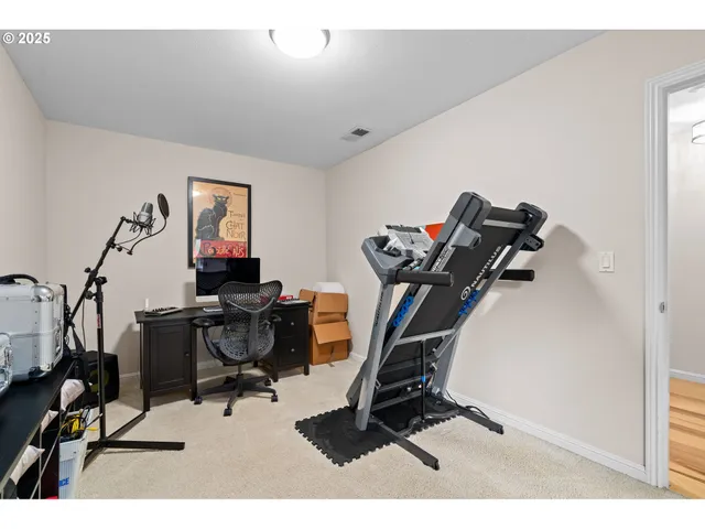 a view of a workspace with furniture and a gym cycle