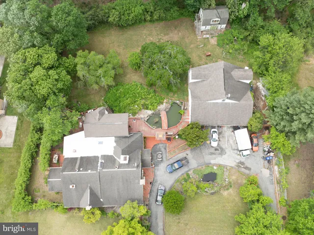 an aerial view of a house with outdoor space and a lake view in back