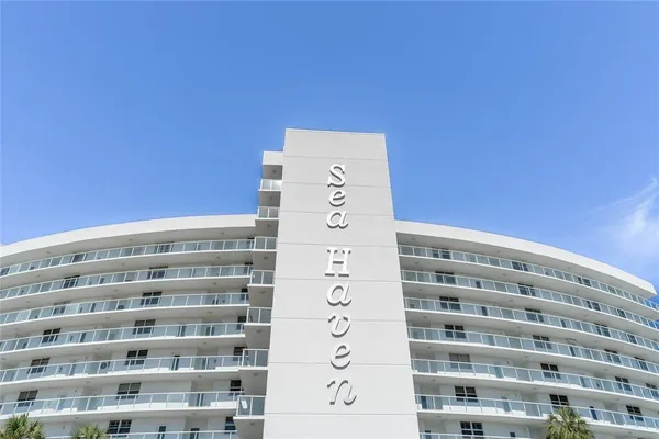 a front view of multi story residential apartment building with yard and green space