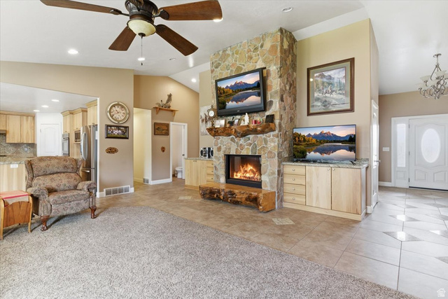 6237 West 4600th Street South Hooper, UT 84315 - Photo 6 of 48 Living area featuring lofted ceiling, a ceiling fan, light tile patterned flooring, light colored carpet, and a stone fireplace