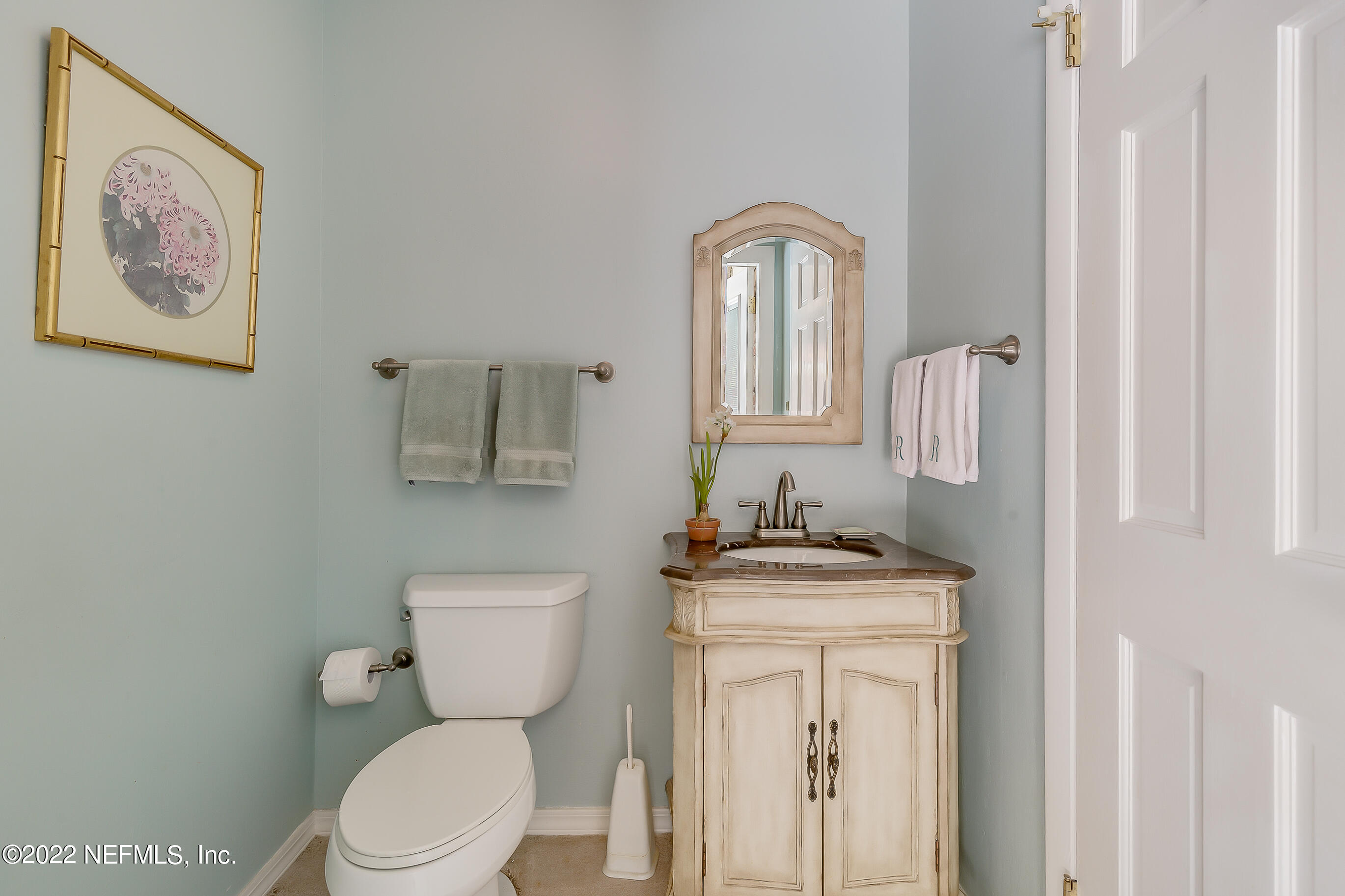 9475 Woodhaven Road Jacksonville, FL 32257 - Photo 27 of 78 a bathroom with a toilet a sink and mirror