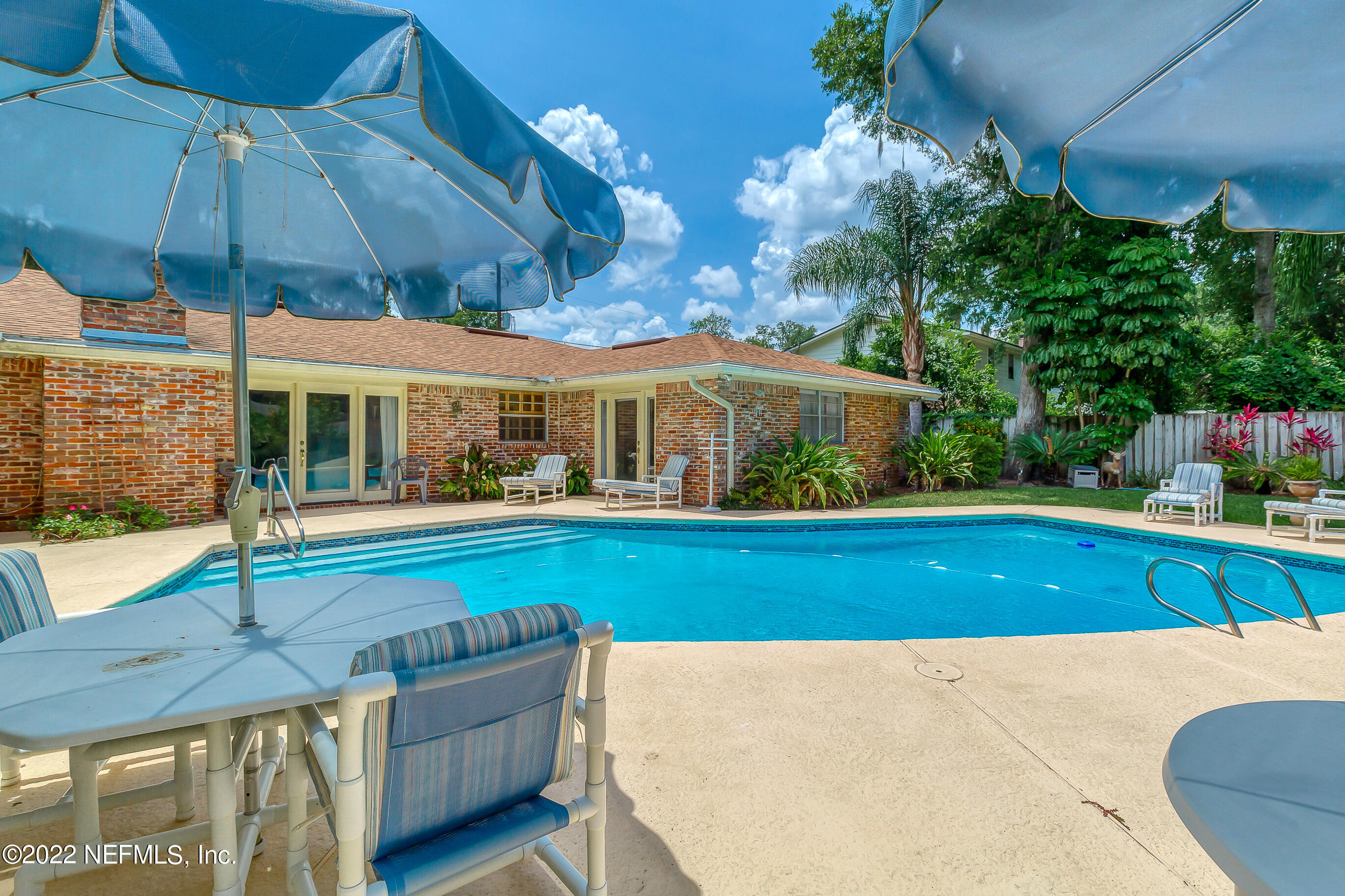 9475 Woodhaven Road Jacksonville, FL 32257 - Photo 50 of 78 a view of swimming pool with lawn chairs under an umbrella