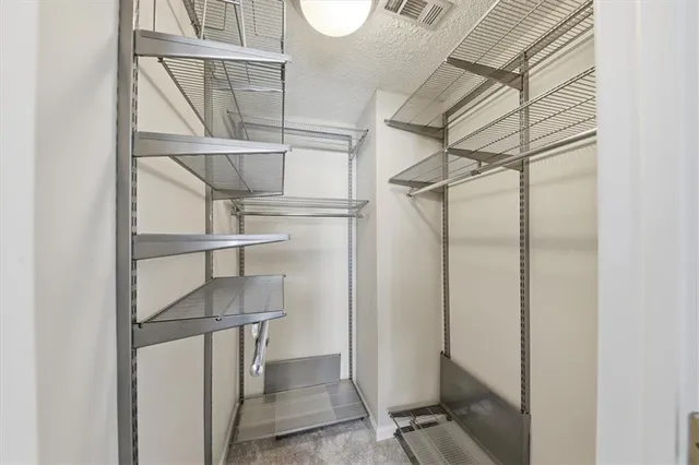 a view of walk in closet with empty racks