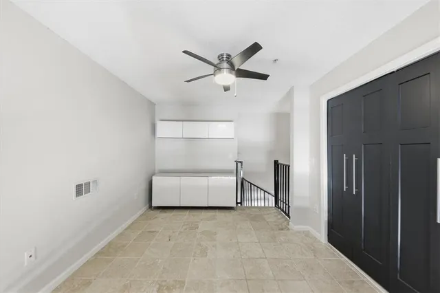 a view of empty room with cabinet and ceiling fan