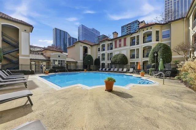 a view of a white building with swimming pool in front of it