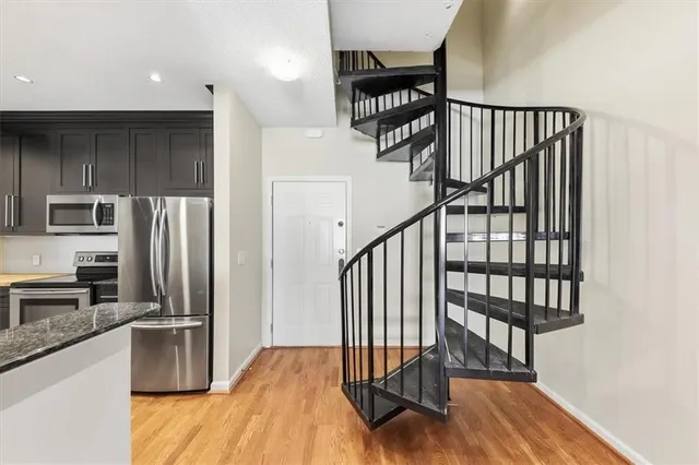 a view of a kitchen with furniture a refrigerator and wooden floor