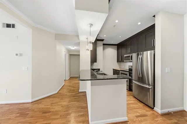 a kitchen with stainless steel appliances granite countertop a refrigerator and a sink