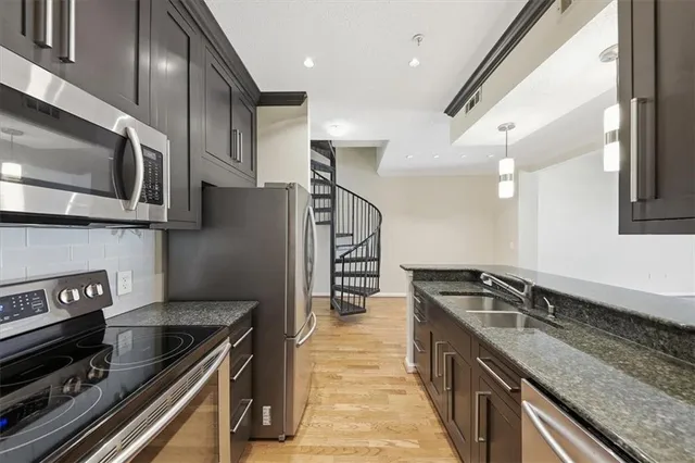 a kitchen with stainless steel appliances granite countertop a sink a stove oven and cabinets