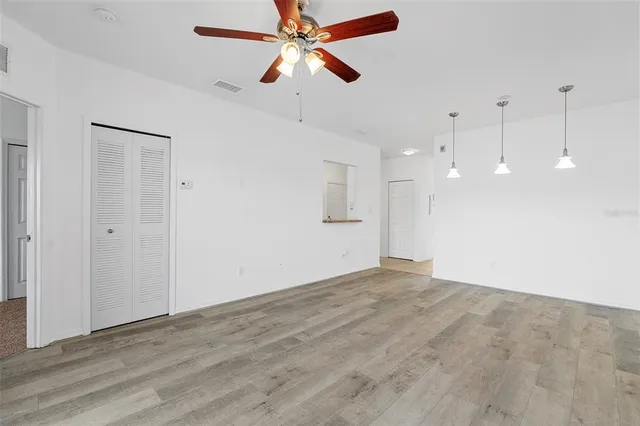 a view of an empty room and kitchen view