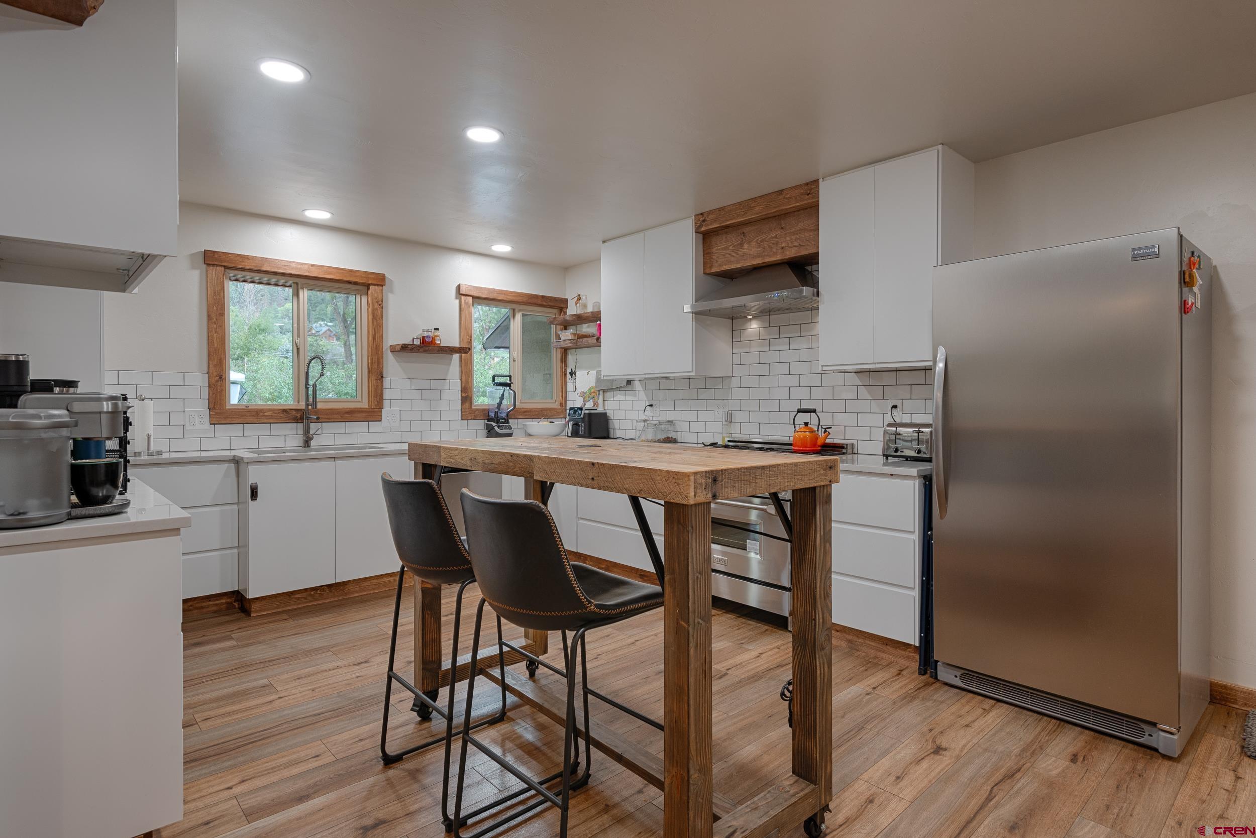 559 Suzanne Lane Ridgway, CO 81432 - Photo 8 of 45 a kitchen with a table chairs refrigerator and microwave