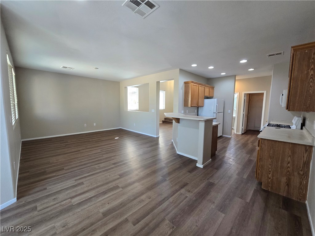 9560 Parker Springs Court Las Vegas, NV 89166 - Photo 37 of 37 Kitchen with light countertops, open floor plan, white appliances, brown cabinets, and a peninsula
