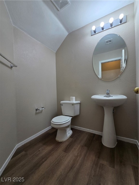 9560 Parker Springs Court Las Vegas, NV 89166 - Photo 15 of 37 Half bath with dark wood-style floors, vaulted ceiling, and a textured wall