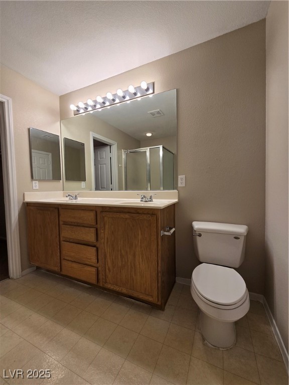 9560 Parker Springs Court Las Vegas, NV 89166 - Photo 23 of 37 Bathroom featuring double vanity, a shower stall, light tile patterned floors, and a textured wall