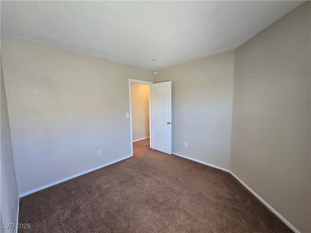 9560 Parker Springs Court Las Vegas, NV 89166 - Photo 27 of 37 Spare room featuring dark carpet and baseboards