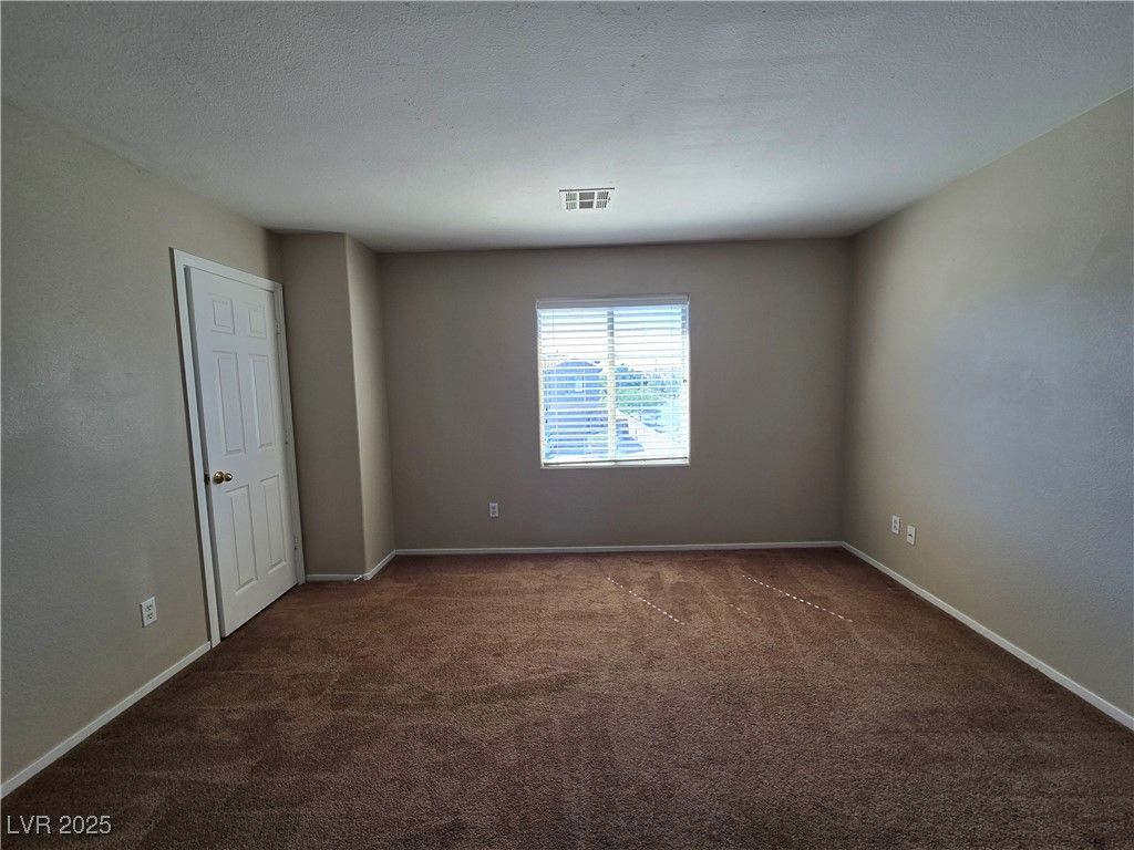 9560 Parker Springs Court Las Vegas, NV 89166 - Photo 29 of 37 Empty room featuring dark carpet and a textured ceiling