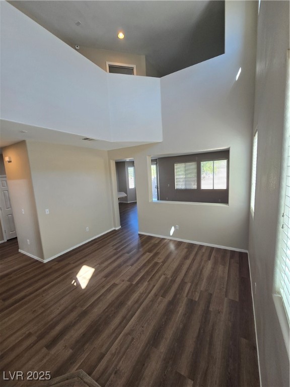 9560 Parker Springs Court Las Vegas, NV 89166 - Photo 5 of 37 Empty room featuring a towering ceiling, dark wood finished floors, and recessed lighting