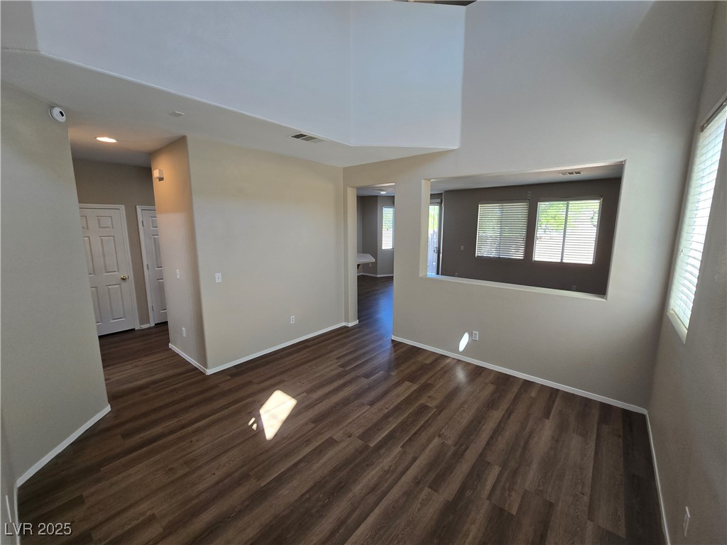 9560 Parker Springs Court Las Vegas, NV 89166 - Photo 6 of 37 Empty room with dark wood finished floors and a high ceiling
