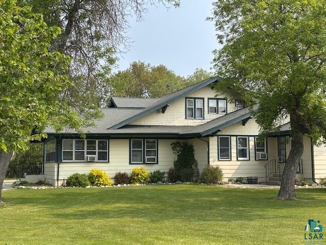 View of front of house with a front lawn and cooling unit