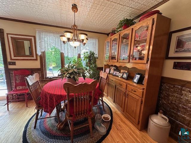 1601 4th Avenue International Falls, MN 56649 - Photo 15 of 50 Dining area with crown molding, a chandelier, light wood finished floors, and an ornate ceiling