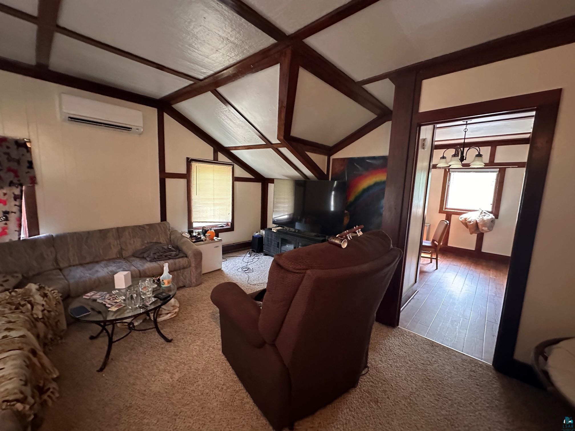 1601 4th Avenue International Falls, MN 56649 - Photo 33 of 50 Living area featuring a wall unit AC, vaulted ceiling, and carpet floors