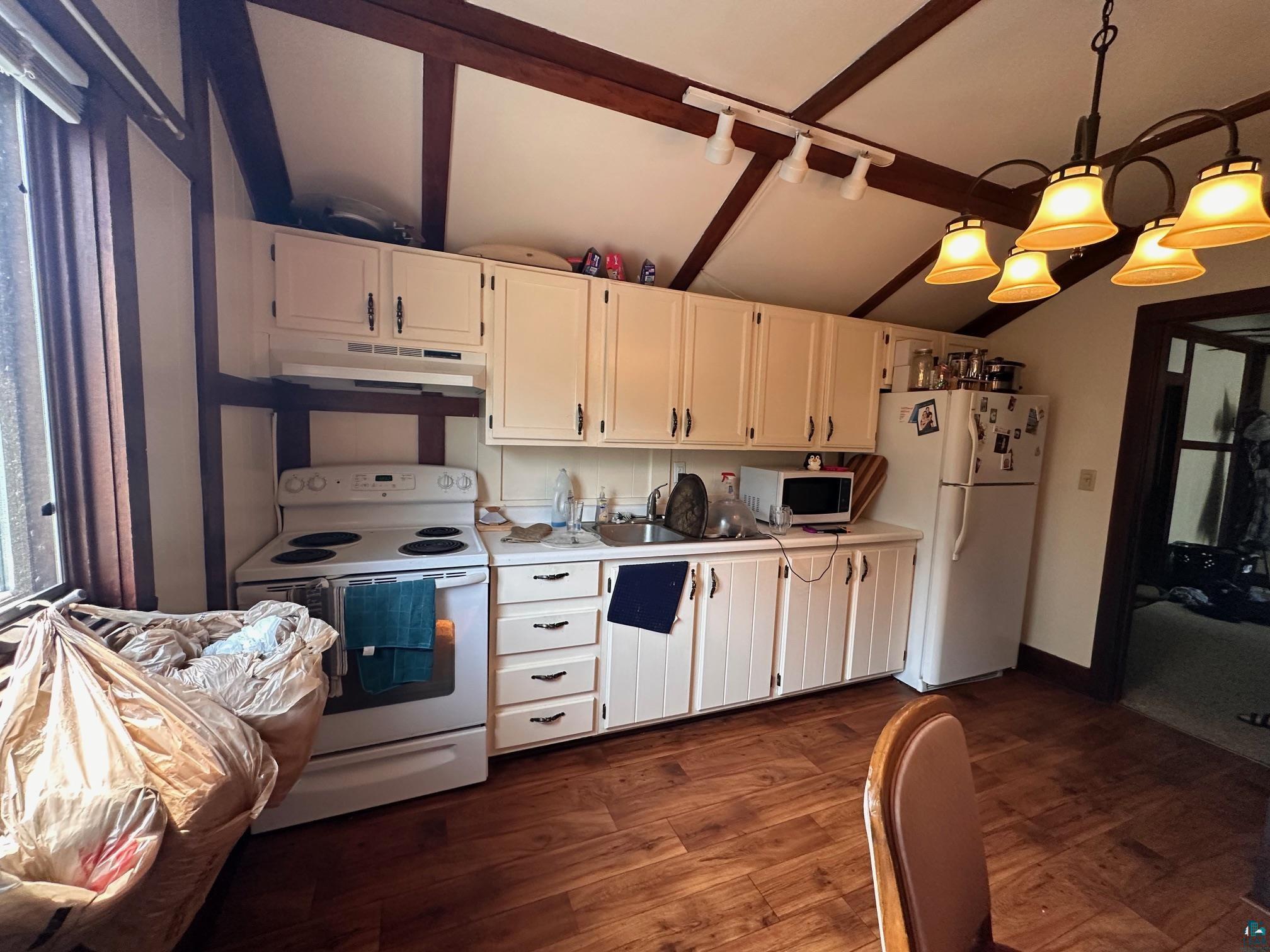 1601 4th Avenue International Falls, MN 56649 - Photo 35 of 50 Kitchen with white appliances, under cabinet range hood, white cabinets, a sink, and light countertops