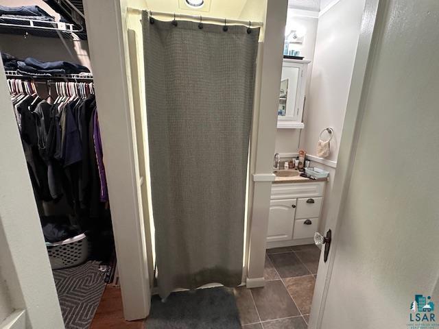 1601 4th Avenue International Falls, MN 56649 - Photo 47 of 50 Bathroom with vanity, a stall shower, a spacious closet, and tile patterned floors