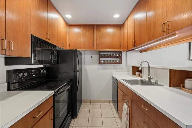 a kitchen with stainless steel appliances a sink a stove cabinets and wooden floor