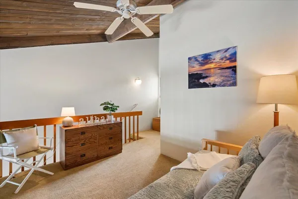 a bedroom with a bed and a lamp on the dresser