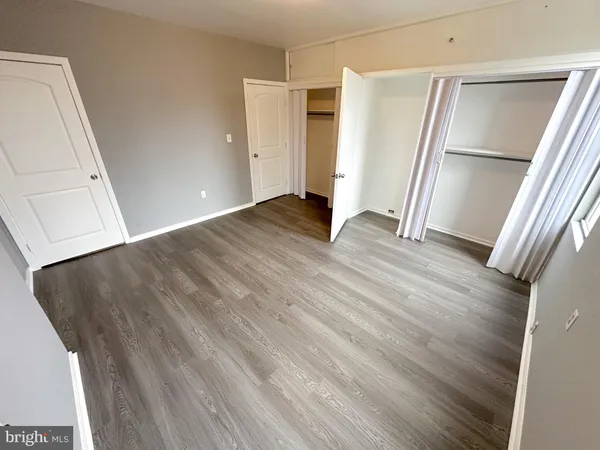 an empty room with wooden floor and entrance