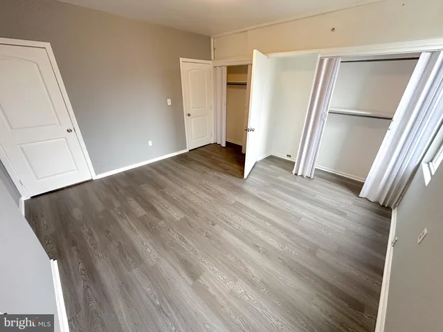 an empty room with wooden floor and entrance