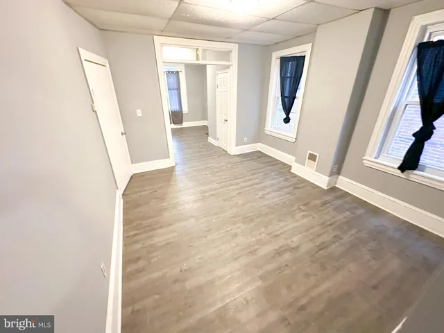 a view of a hallway with wooden floor and stairs