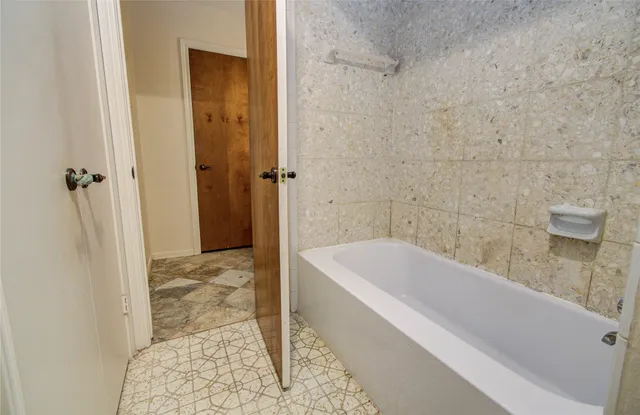 a bathroom with a bathtub and shower