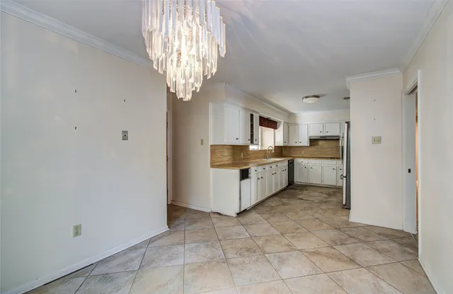 a large white kitchen with a stove a sink dishwasher and a refrigerator