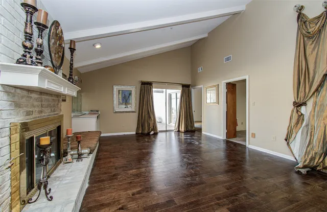 a view of a livingroom with wooden floor and a fireplace
