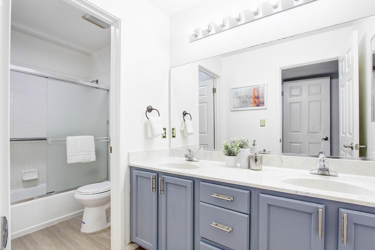 128 Orsi Circle San Francisco, CA 94124 - Photo 30 of 40 a bathroom with a granite countertop sink a toilet and a large mirror