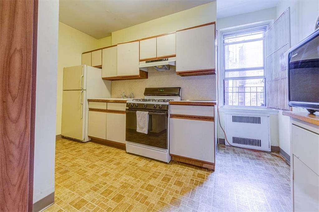 601 79th Street, Unit D11 Brooklyn, NY 11209 - Photo 6 of 19 a kitchen with stainless steel appliances granite countertop a stove and a refrigerator