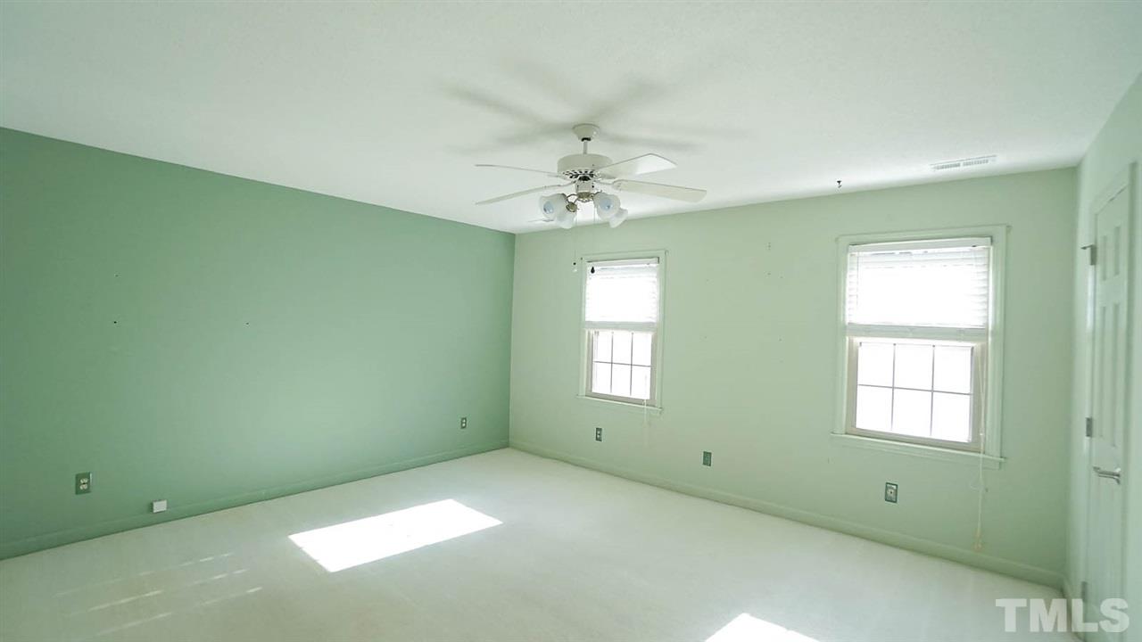 1809 Pony Run Road Raleigh, NC 27615 - Photo 22 of 30 an empty room with a window and a ceiling fan