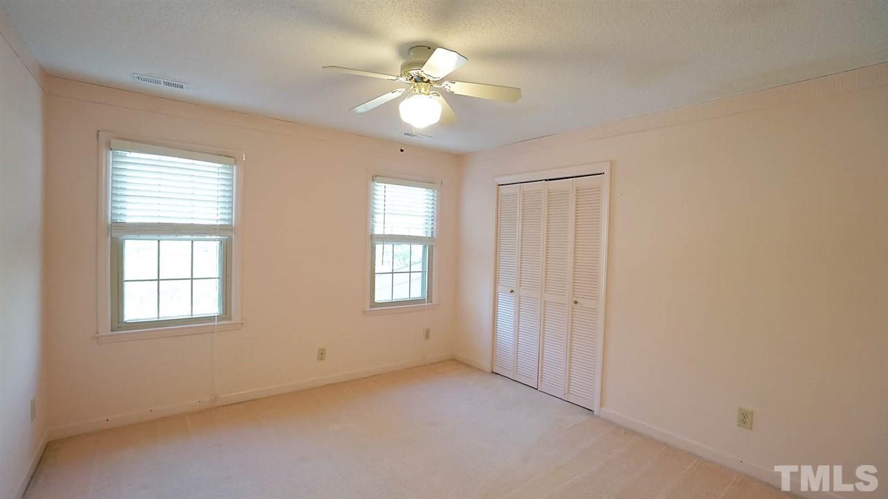1809 Pony Run Road Raleigh, NC 27615 - Photo 23 of 30 an empty room with windows and chandelier fan