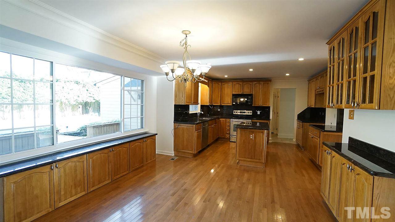 1809 Pony Run Road Raleigh, NC 27615 - Photo 8 of 30 a large kitchen with kitchen island a large counter space a sink appliances and a window
