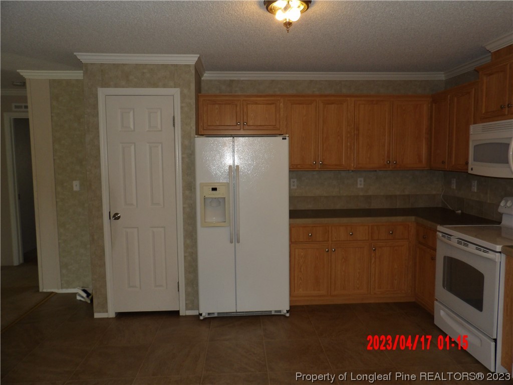 7349 Roslin Farm Road Hope Mills, NC 28348 - Photo 3 of 23 a kitchen with a refrigerator and a stove top oven