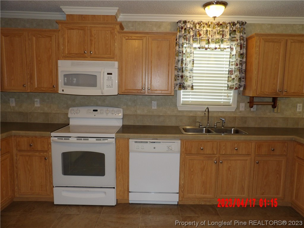 7349 Roslin Farm Road Hope Mills, NC 28348 - Photo 4 of 23 a kitchen with granite countertop a sink stainless steel appliances and cabinets